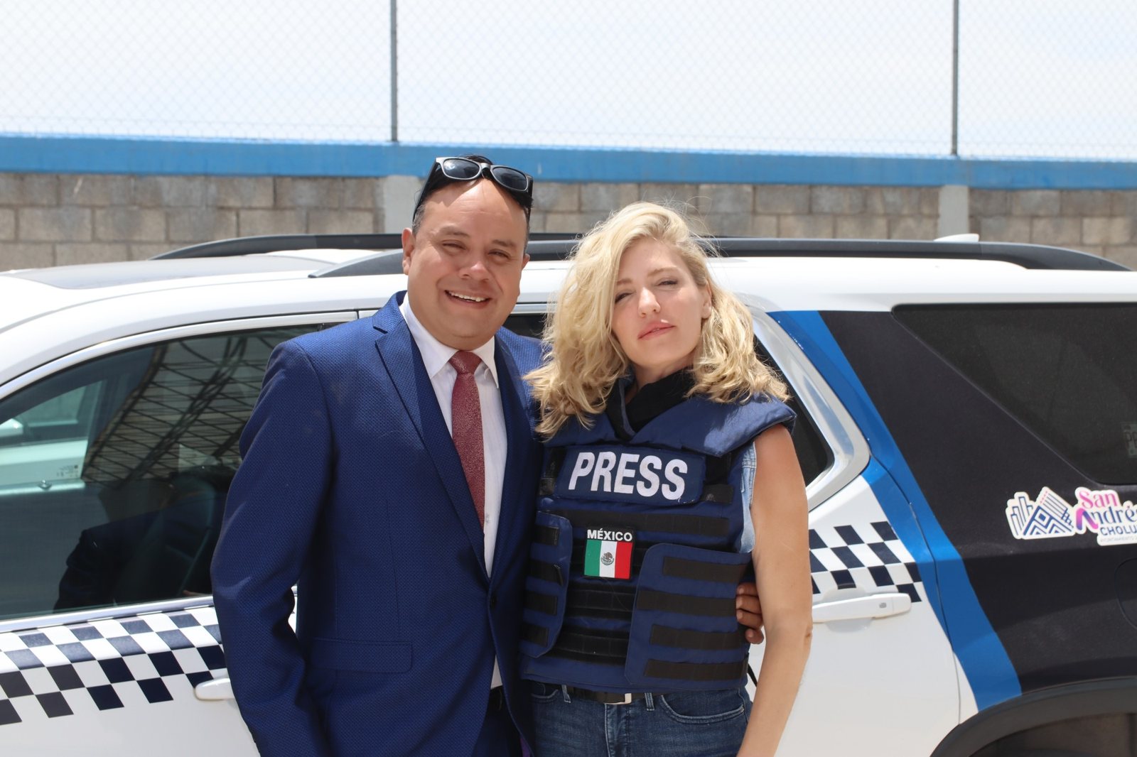 Thaís Armengol con chaleco de prensa junto a una patrulla de la policía municipal de San Andrés Cholula, Puebla (México)