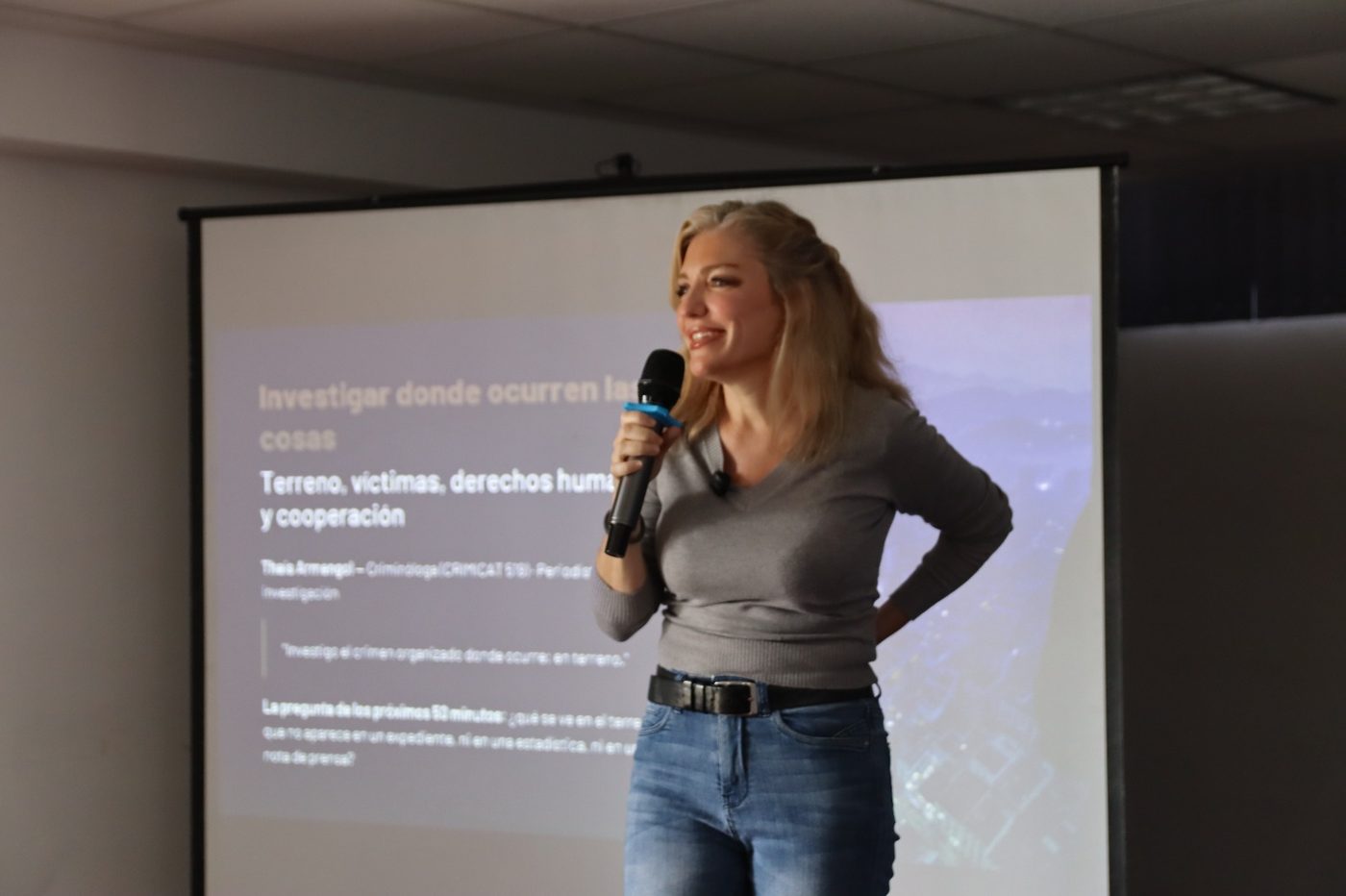 Thaís Armengol impartiendo la ponencia en IDEAUNI, ante la diapositiva «Investigar donde ocurren las cosas»